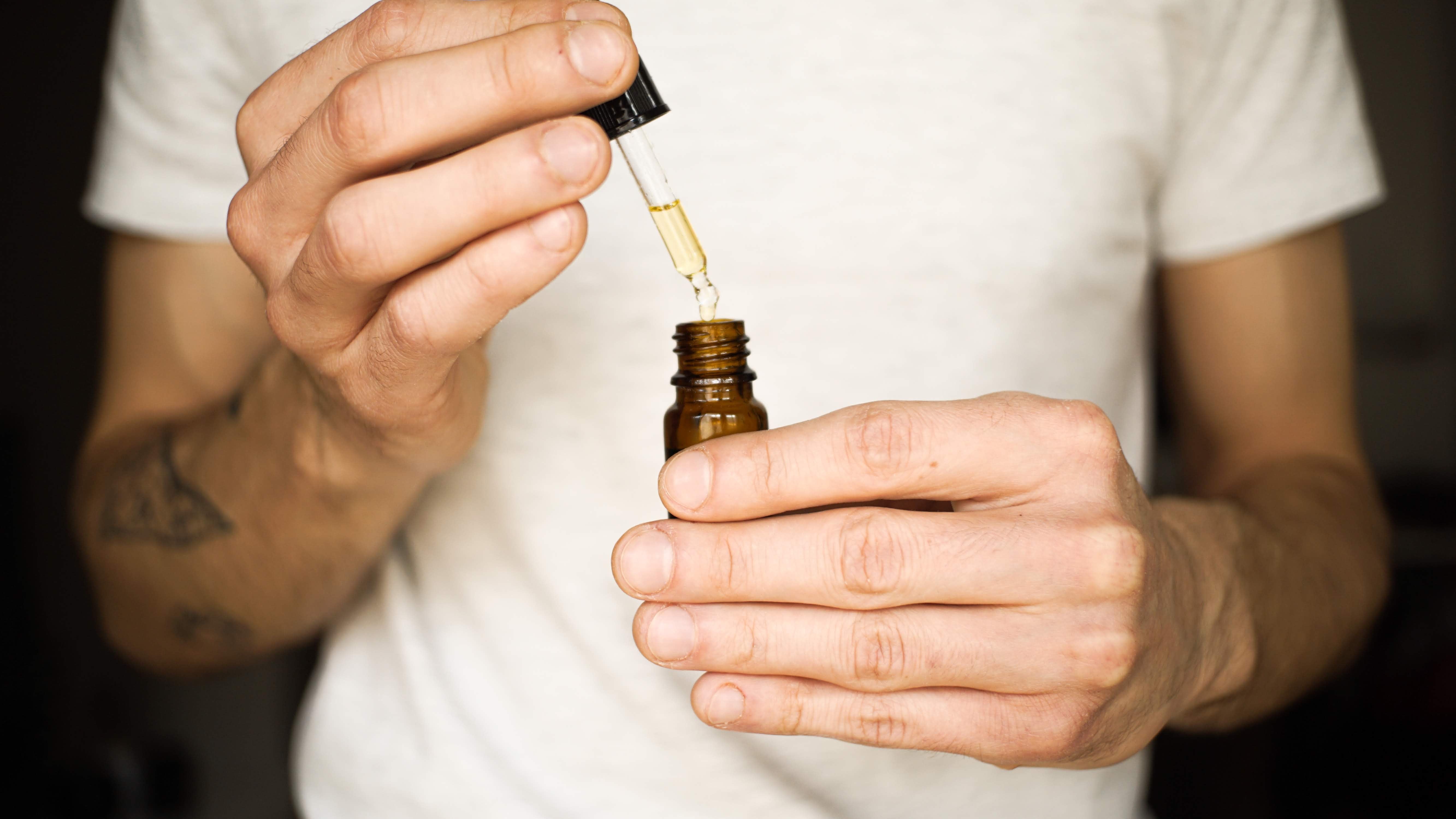 Man holding oil dropper